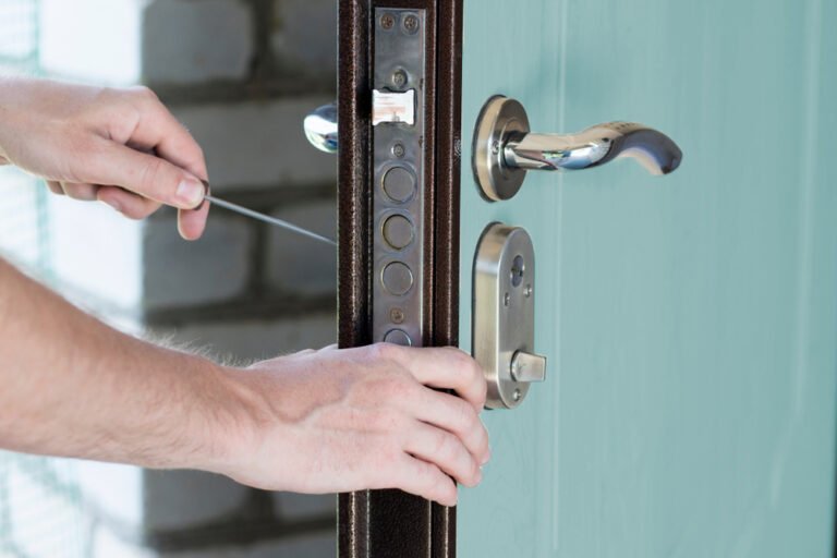 Serrurier ouvrant une porte blindée à l’aide d’un outil de crochetage, vue sur la serrure.